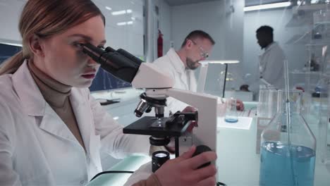 Diversos-científicos-estudiando-muestras-médicas.-Uso-de-computadoras-y-microscopios.-Interior-de-laboratorio-moderno