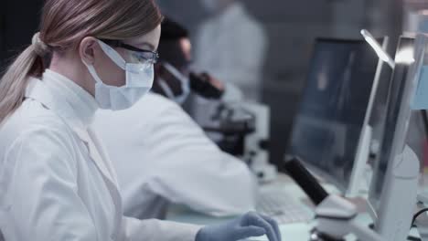 Diverse-scientists-studying-medical-samples.-Using-computers-and-microscopes.-Modern-laboratory-interior