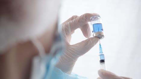 Spritze-und-Fläschchen-des-Impfstoffs-in-den-Händen-des-Arztes.-Vorbereitung-der-Injektion