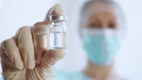 Woman-Doctor-In-Medical-Uniform-Holds-Glass-Vial-Vaccine,-4k