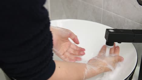 Slow-motion-video-of-woman-clean-up-the-foam-in-the-bathroom-sink