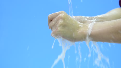 Slow-motion-video-of-washing-hand-with-foam-against-blue-background