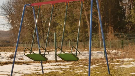 columpio-en-un-parque-infantil-cerca-del-bosque.-el-viento-lo-está-moviendo.-no-hay-niños.