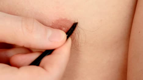 Closeup-of-man's-hand-plucking-the-hairs-around-the-nipple.