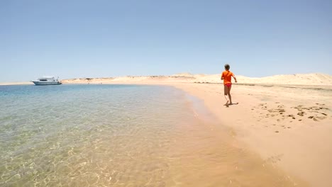 Girl-in-swimwear-running-away-on-the-sea-beach-in-desert