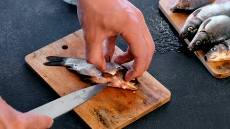 Man-gutting-a-carp-fish.-Cooking-fish.-Hands-close-up.