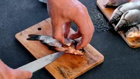 Hombre-destripado-un-pez-carpa.-Cocinar-el-pescado.-Primer-plano-de-las-manos.