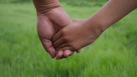 Hand-des-Vaters-an-der-Tochter-Hand-in-Slow-Motion-Szene-hautnah