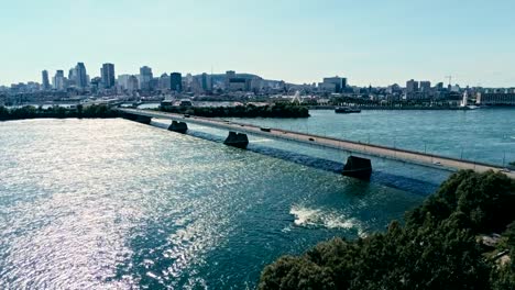 aerial-drone-footage-of-montreal-with-bridges-and-skyscrapers-in-the-background-on-the-horizon