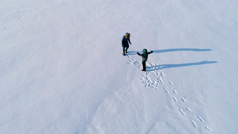 Mutter-und-Sohn-spielt-Schneeball-im-Winter.-Zeit-mit-der-Familie-spazieren-und-spielen-zusammen