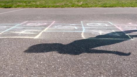 Boy-jumps-playing-hopscotch-in-the-street.-Close-up-legs.-Side-view.