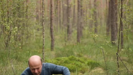 Senior-man-walking-and-picking-mushrooms-in-forest.-Suddenly-he-falls-down-because-of-leg-injury