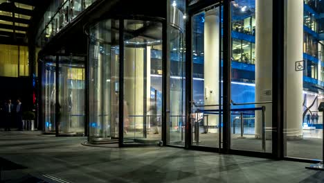 the-flow-of-people-passing-through-the-revolving-door-of-the-modern-office-building-at-the-end-of-the-working-day,time-lapse