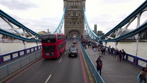 Drone-shot-of-a-black-taxi-cab-driving-on-the-iconic-Tower-Bridge-in-London,-Great-Britain