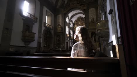 Young-lady-sitting-on-bench-in-cathedral