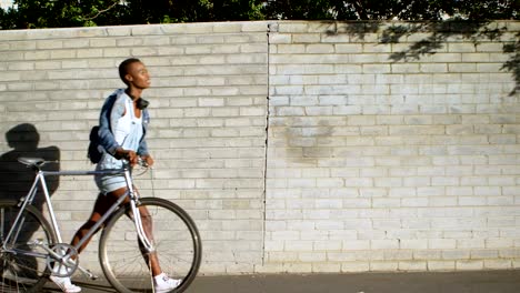 Frau-zu-Fuß-mit-dem-Fahrrad-in-die-Stadt-Straße-4k