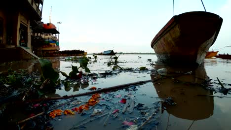 Inundación-en-Manikarnika-Ghat-lugar-de-cremación-de-Varanasi-las-ramas-negras-flotan-en-barco-de-río-en-el-muelle-de-ladridos-lejos-con-leña-y-crematorios-de-gas
