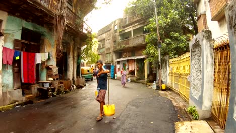 alte-Straße-schäbige-Gebäude-bengalis-Menschen-gehen-tragen-Wasser-Schulmädchen-Jungen-Reiten-Fahrrad-Kolkata