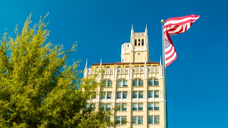 Downtown-Asheville,-NC-Architecture-with-American-Flag-and-Blue-Sky