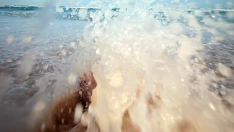 Girl-Sitting-on-the-Beach-and-Getting-her-Feet-Wet