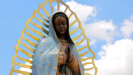 Tilt-to-Reveal-a-Statue-of-the-Virgin-Guadalupe-and-an-Adobe-Catholic-Church