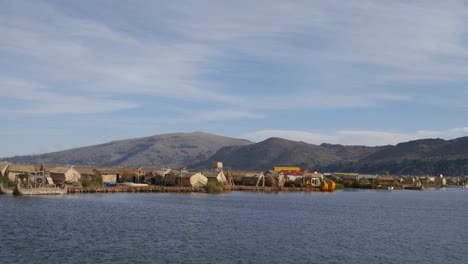 View-of-the-Uros-floating-reed-islands-with-boats,-mysterious-Lake-Titicaca,-Puno-Region,-Peru