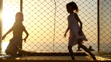 los-niños-jugar-en-el-patio-con-un-trampolín