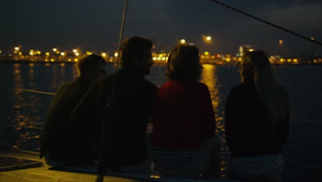 Gruppe-von-Menschen,-die-sich-nachts-auf-einer-Yacht-im-Meer-entspannen.