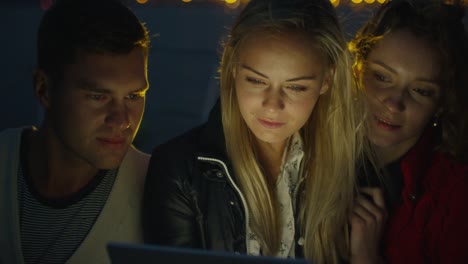 Group-of-people-are-using-tablet-on-a-yacht-in-the-sea-at-night.