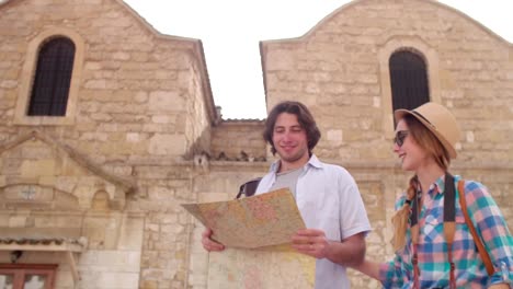 Pareja-de-jóvenes-turistas-con-visitar-una-antigua-ciudad-mapa