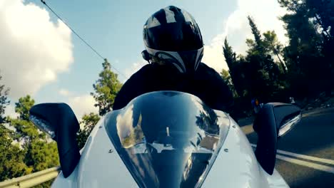 POv-shot-of-a-man-riding-on-a-white-sports-motorcycle-on-a-curved-road