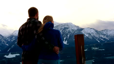 Couple-standing-and-embracing-each-other-on-snowy-landscape