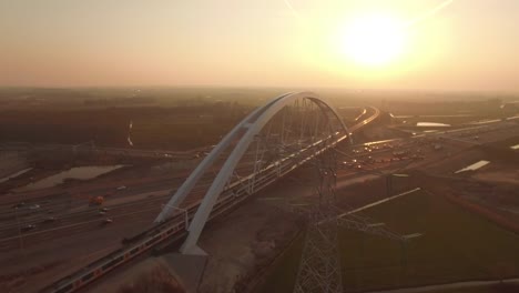 Nuevo-puente-construido-sobre-una-carretera-con-tráfico,-en-puesta-de-sol