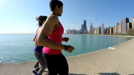 Multi-étnica-americana-amigos-corriendo-por-el-lago-Michigan