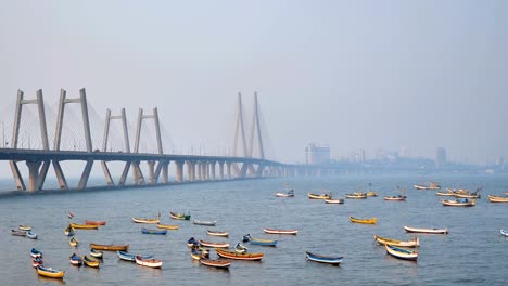 Bunte-Fischerboote-sind-unter-den-modernen-Kabelbrücke-übernachteten-geparkt.