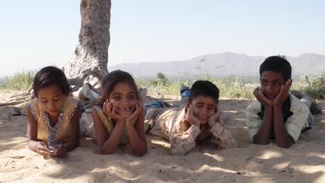 Indian-children-portrait-happy-and-excited,-playing-and-making-merry-in-sand-area-in-Rajasthan-state-of-India