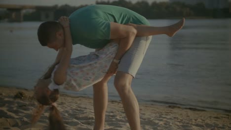 Glücklicher-Vater-Spaß-mit-Tochter-am-Strand