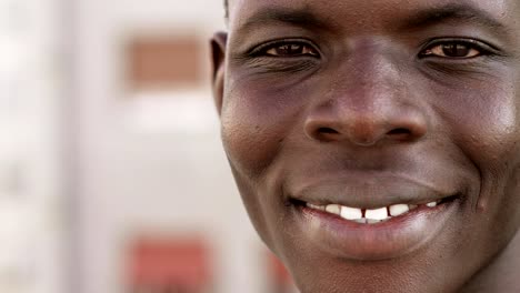 Handsome-young-black-african-man-smiling-at-camera--close-up