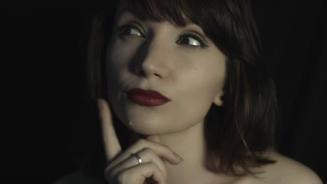 4k-shoot-of-a-woman-in-studio-thinking-and-smiling-at-camera