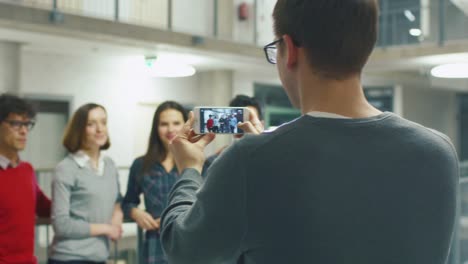 Männliche-Schüler-macht-ein-Bild-mit-einem-Telefon,-einer-Gruppe-von-Freunden-in-der-Schule.