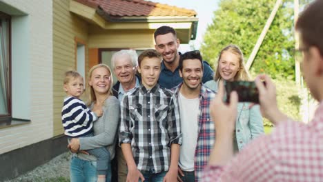 Hombre-tomando-fotos-al-aire-libre-de-su-gran-familia.