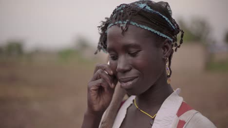 Porträt-einer-jungen-afrikanischen-Bäuerin,-die-spontan-auf-ihrem-Handy-spricht