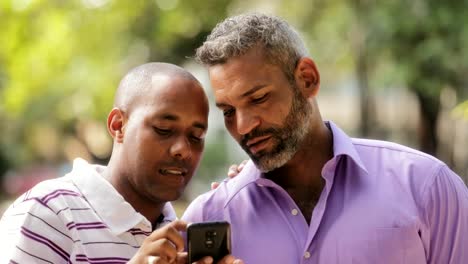 Pareja-de-Gay-Lgbt-feliz-mirando-fotos-en-teléfono-móvil