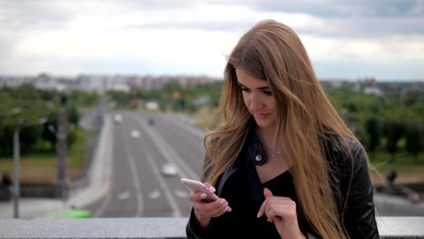 Mujer-joven-utiliza-un-Smartphone-y-endereza-el-pelo