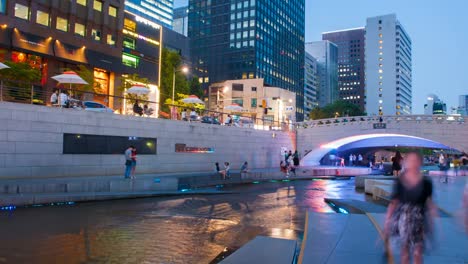 Parque-de-arroyo-de-Cheonggyecheon-con-multitud-de-personas-relajación-en-Seúl,-Corea-del-sur.-Lapso-de-tiempo-de-4K