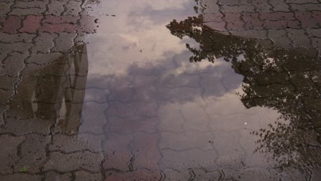 Timelapse-view-of-reflecte-sky-on-water-at-sidewalk-block-after-rain