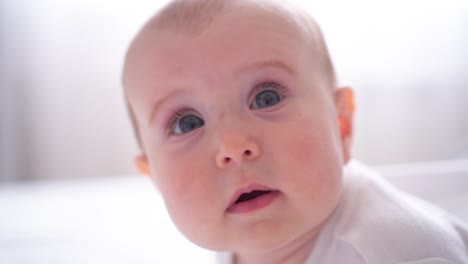 Süße-kleine-Baby-auf-dem-Bauch-liegend-und-Blick-in-die-Kamera