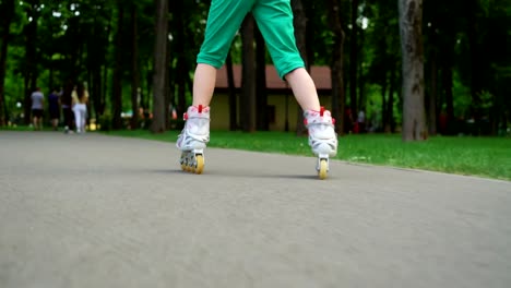 Carefree-young-girls-making-selfies-skating-rollers-in-park-outdoo