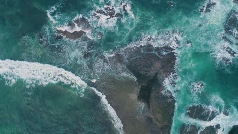 Olas-del-mar-golpeando-rocas-lenta-capturan-una-vista-aérea