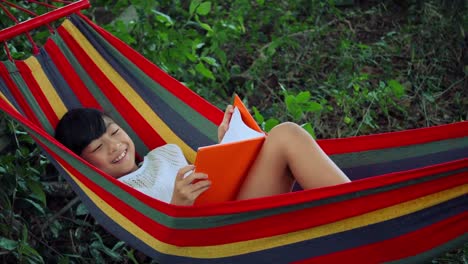 Little-girl-chilling-on-hammock-and-reading-a-book-story